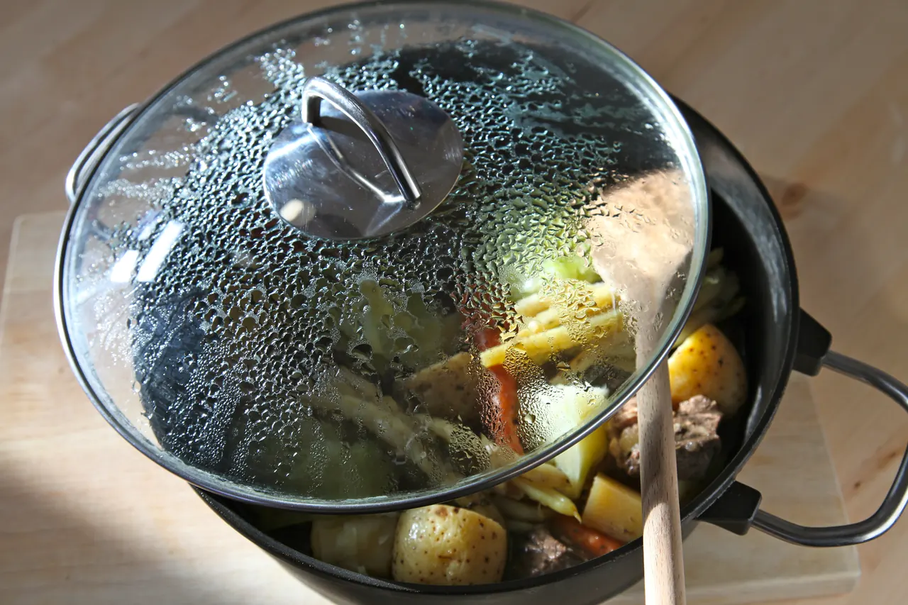 Beef and vegetables slowly cooking in a covered pot