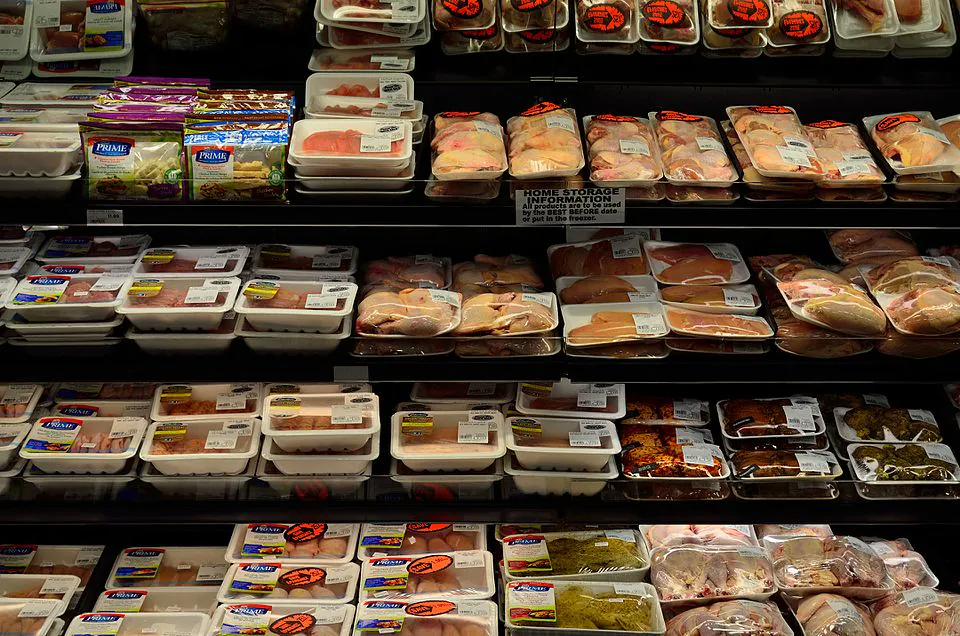 Refrigerated supermarket case with packaged meat arranged on shelves